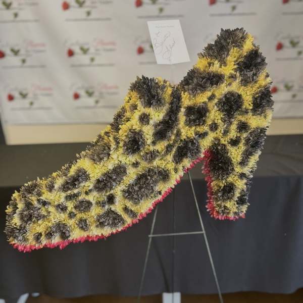 Large floral number-shaped standing arrangement in yellow, black, and pink
