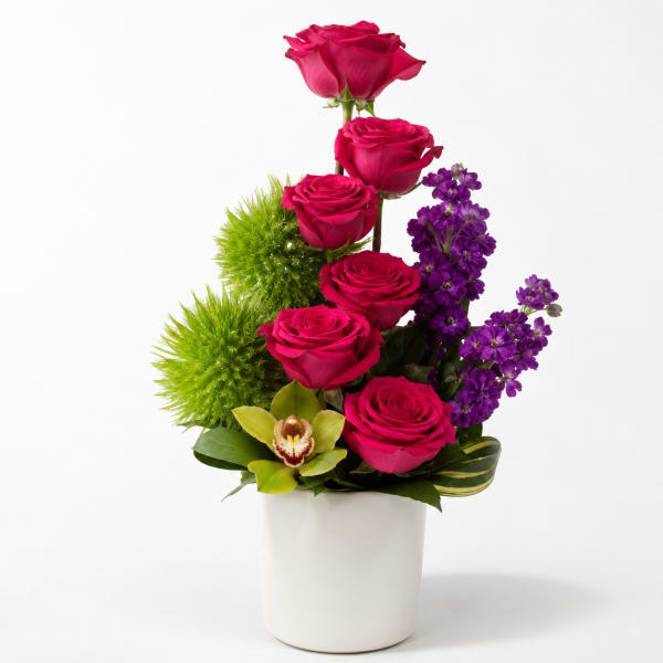 Pink roses and purple flowers in a white vase