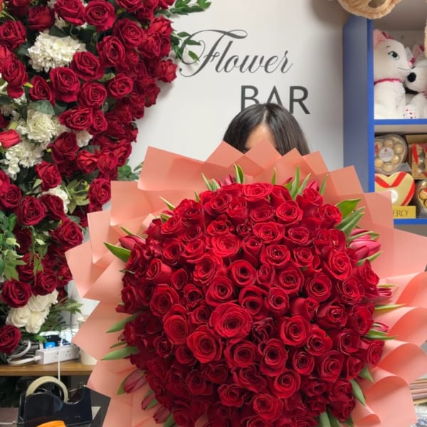 Large bouquet of red roses wrapped in pink paper