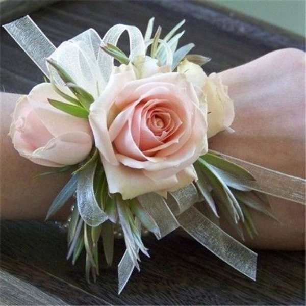 Pink rose wrist corsage with white ribbon and greenery