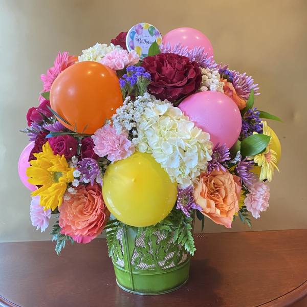 Colorful bouquet with balloons in a green vase