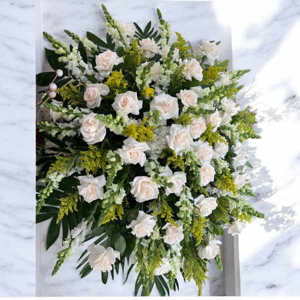 Large white rose arrangement with green and yellow accents