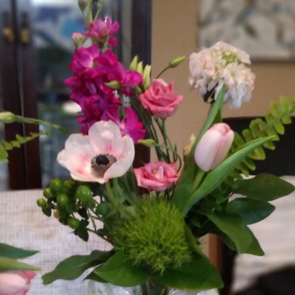 Pink and white mixed bouquet in a glass vase with a ribbon