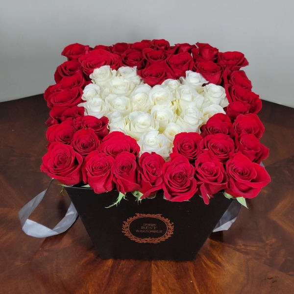 Heart-shaped box of red and white roses on a table