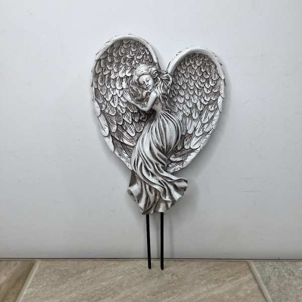 Silver angel figurine with large wings on a heart-shaped plaque