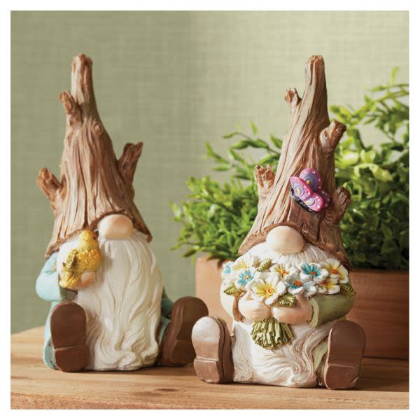 Two gnome figurines holding flowers and a butterfly decoration
