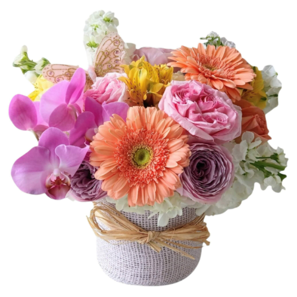Mixed bouquet of pink, peach, and white flowers in a wrapped container
