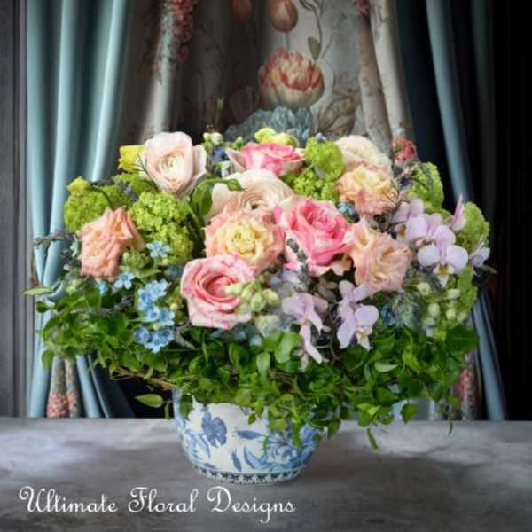 Mixed pink and cream roses in a blue-and-white ceramic vase