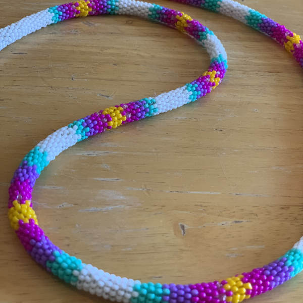 Colorful beaded necklace laid on a wooden surface