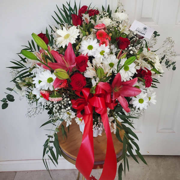 Large bouquet of red, white, and pink flowers with a red ribbon