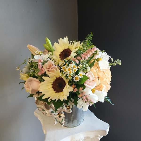 Bouquet of sunflowers, roses, daisies, and hydrangea in a metal vase