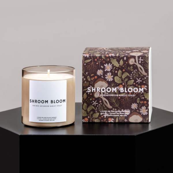 Scented candle in a glass jar beside its floral-patterned box