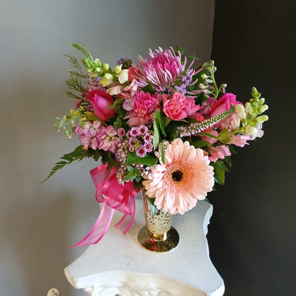 Pink and peach mixed bouquet in a gold vase with a ribbon