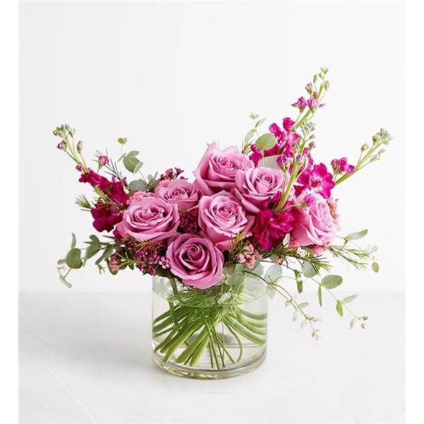 Pink rose bouquet in a clear glass vase with airy magenta accents