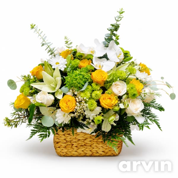 Yellow and white floral arrangement in a woven basket