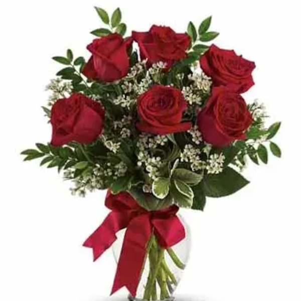 Bouquet of red roses in a clear glass vase with a red ribbon