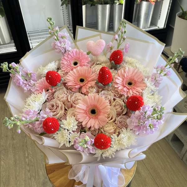 Pink gerbera and roses bouquet with red strawberry decorations