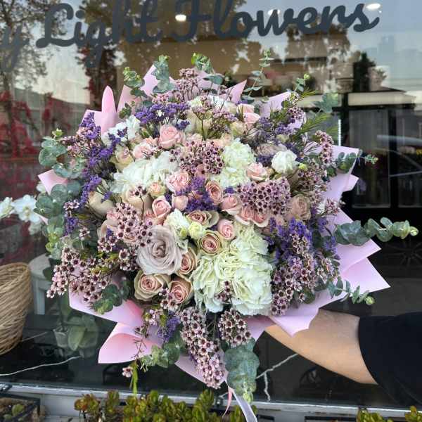 Large bouquet of pink and white roses with purple accents and eucalyptus