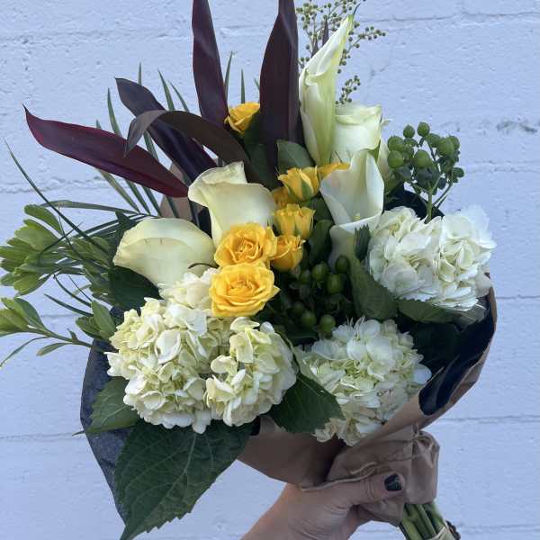 Bouquet of white calla lilies, yellow roses, and white hydrangeas