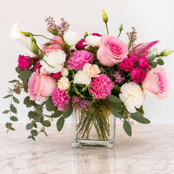 Pink and white flower arrangement in a clear glass vase