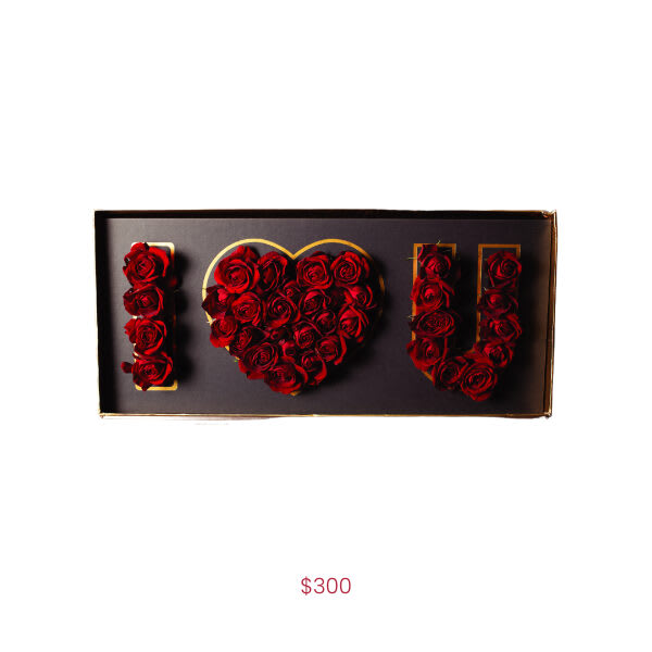Red roses arranged to spell "I LOVE U" in a gift box