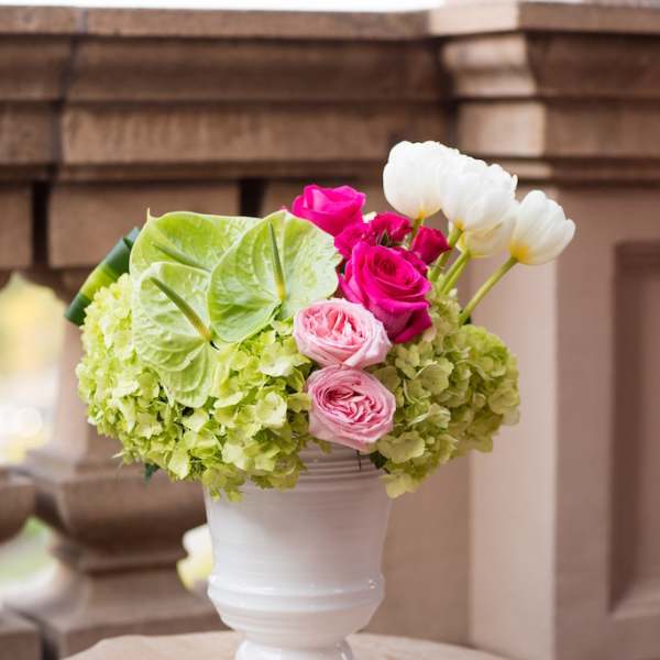 Pink and white roses with green hydrangeas in a white vase