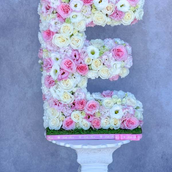 Floral letter E made of pink and white roses with a silver crown