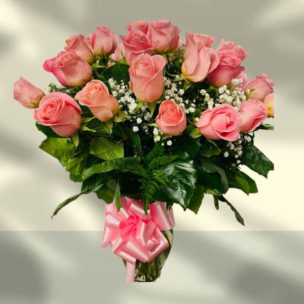 Bouquet of pink roses with baby's breath in a glass vase