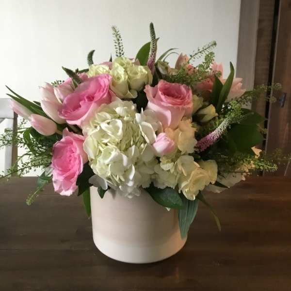 Pink and white roses with hydrangeas in a white vase
