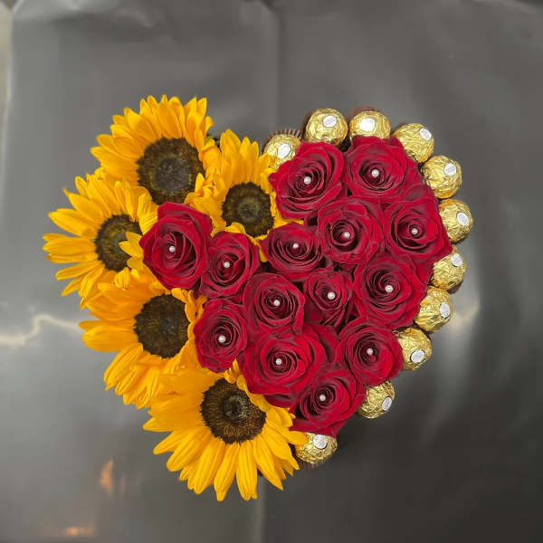 Heart-shaped bouquet of red roses and sunflowers with gold chocolates