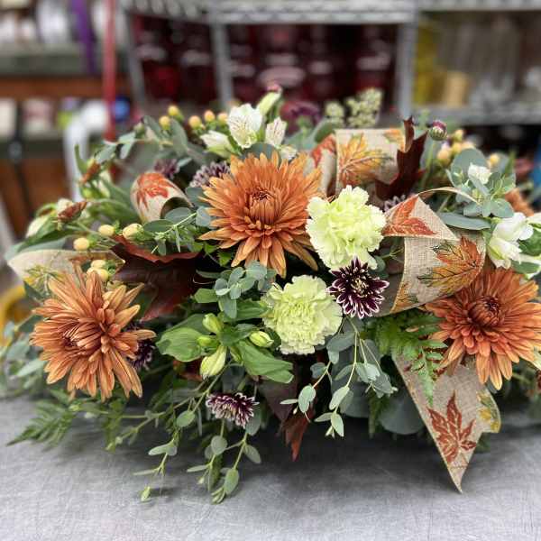 Autumn floral arrangement with orange chrysanthemums and pale green carnations