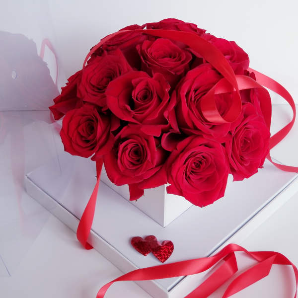 Bouquet of red roses with red ribbon in a white box