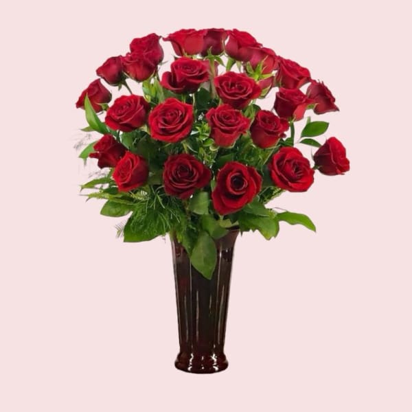 Red roses arranged in a tall dark vase