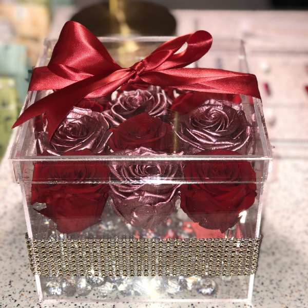Clear gift box with red roses and a red satin bow