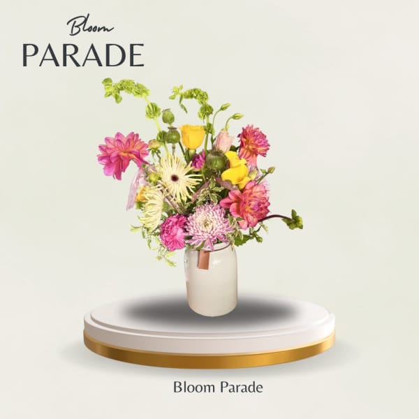Mixed bouquet of pink, yellow, and white flowers in a glass vase