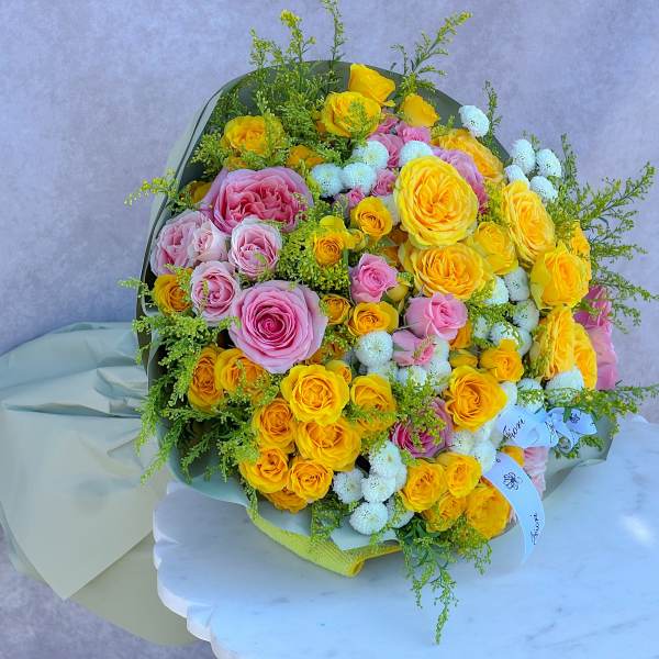 Bouquet of yellow and pink roses with small white flowers