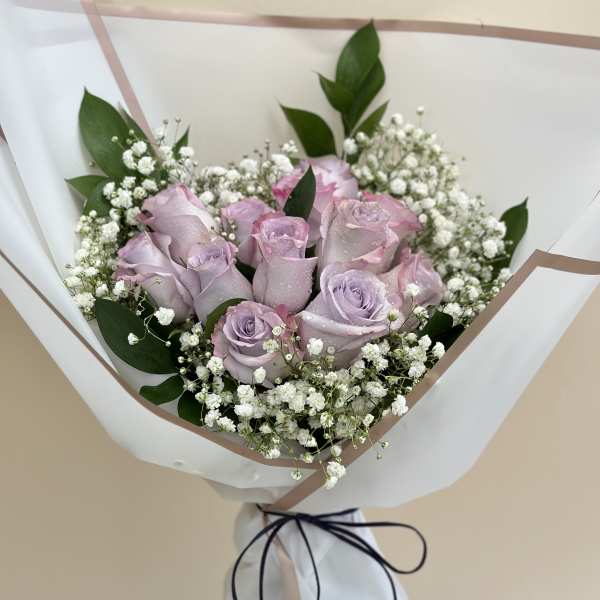 Lavender roses with baby's breath in white wrapping