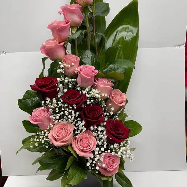 Tall arrangement of pink and red roses in a black vase
