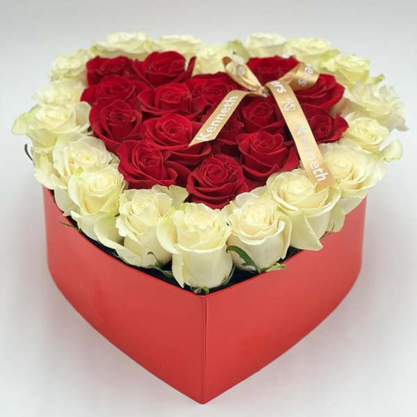 Heart-shaped box of red and white roses with a ribbon