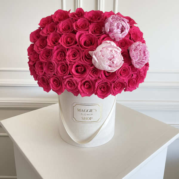 Hot pink and pale pink roses arranged in a white hat box