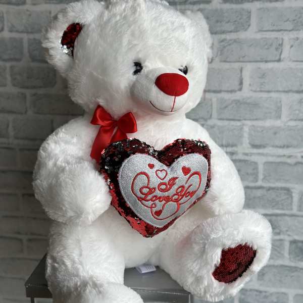 White teddy bear holding a heart with red sequins and "Love You" text