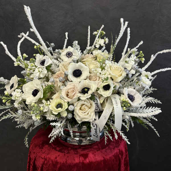 White and blush bouquet with anemones and roses in a silver vase