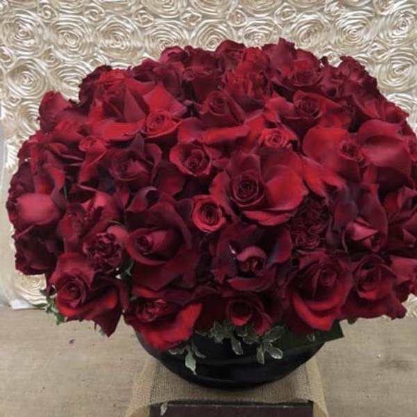 Large bouquet of deep red roses in a black vase