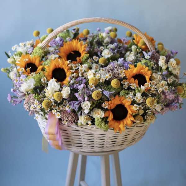 Basket of sunflowers and mixed pastel flowers with a ribbon