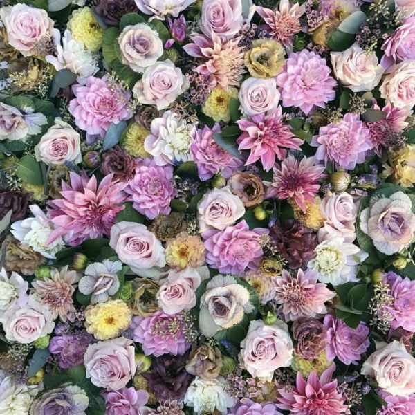 Dense floral arrangement of pink and lavender blooms with roses and dahlias