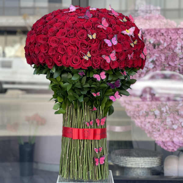 Large bouquet of red roses with pink butterfly accents