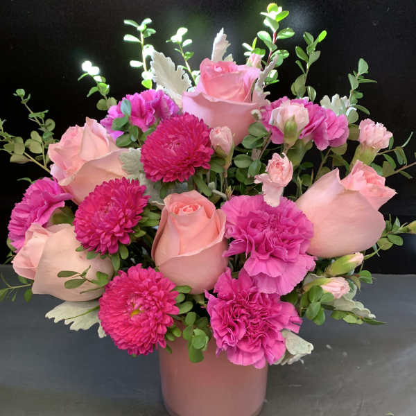 Pink roses and magenta carnations in a pink vase