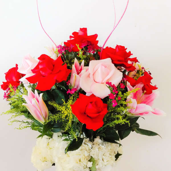 Bouquet of red and pink roses with lilies in a glass vase