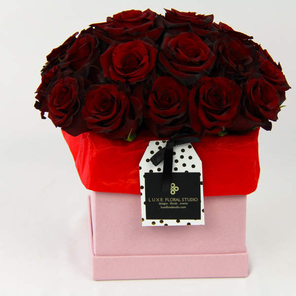 Box of deep red roses in a pink gift box