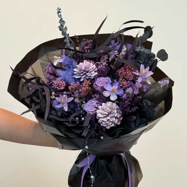 Purple bouquet wrapped in black paper with ribbon